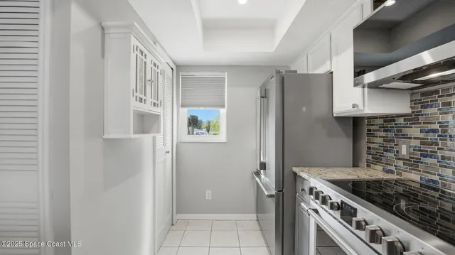 an empty room with a ceiling fan and windows