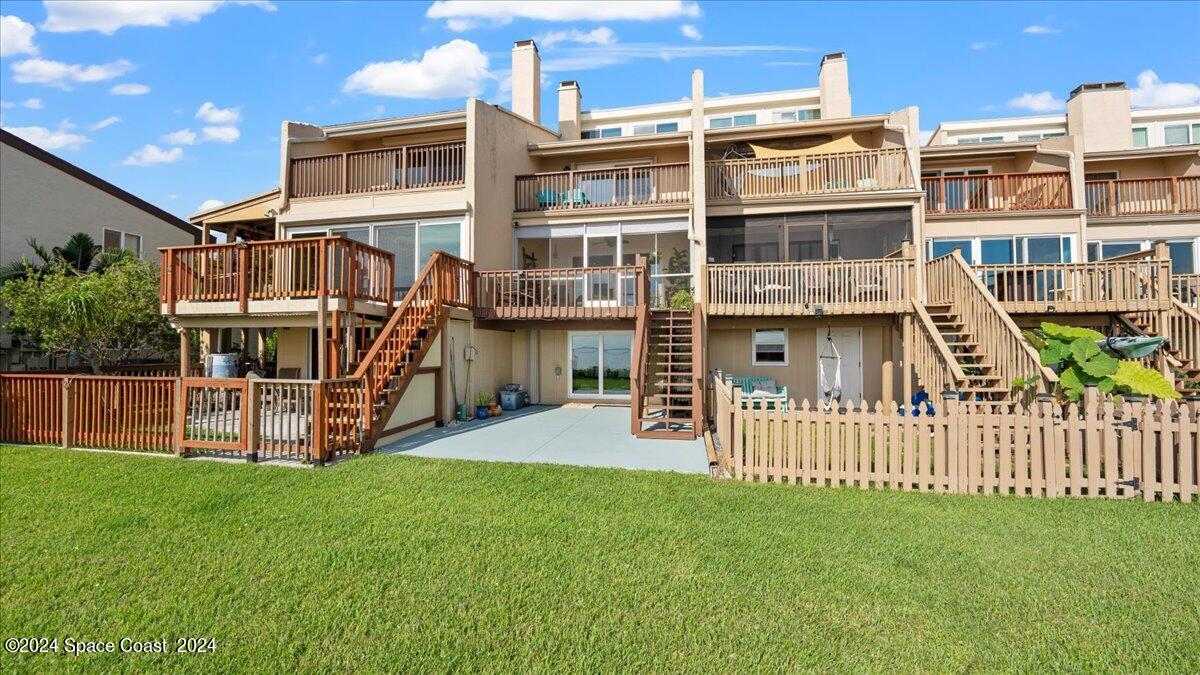 5087 Riveredge Drive, Unit 2 Titusville, FL 32780 - Photo 31 of 62 a front view of a house with a yard table and chairs