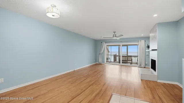 a view of a livingroom with wooden floor and a fireplace