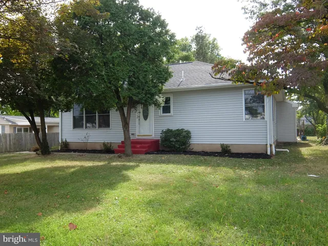 a backyard of a house with table and sofas