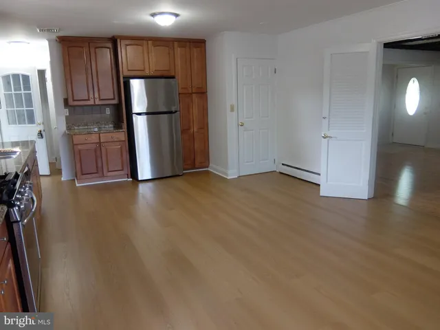 a view of empty room with wooden floor and electronic appliances