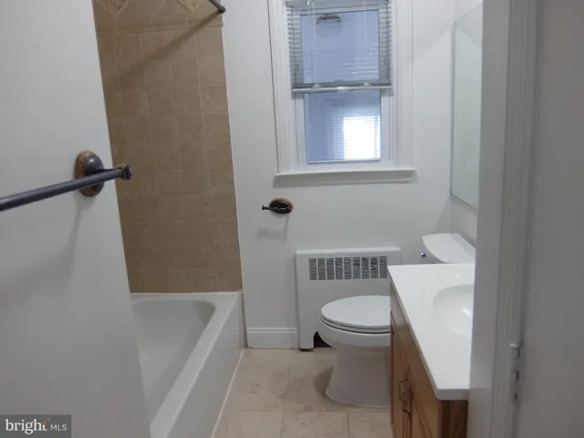 a white toilet sitting next to a bath tub