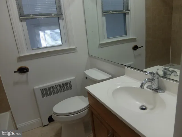 a bathroom with a sink a toilet and mirror