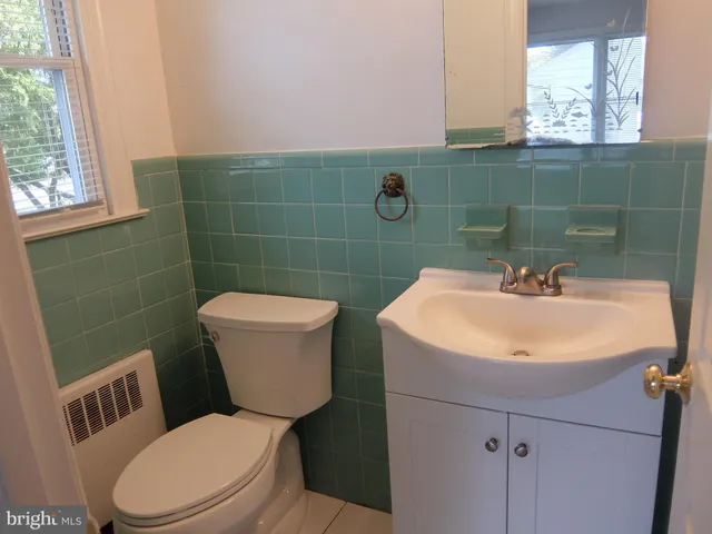 a bathroom with a sink a toilet and a mirror