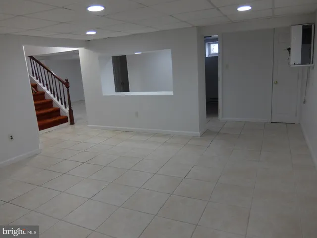an empty room with staircase and mirror