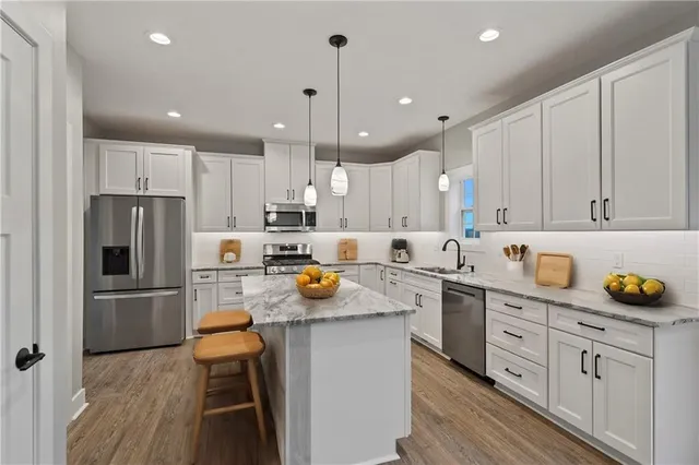 a kitchen with white cabinets and stainless steel appliances