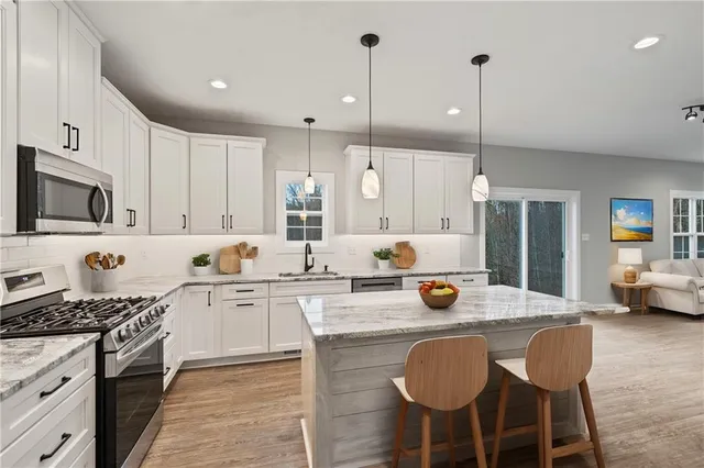 a kitchen with a sink stove and chairs