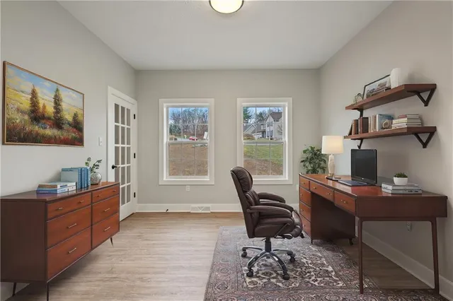 a view of a workspace with furniture and a window