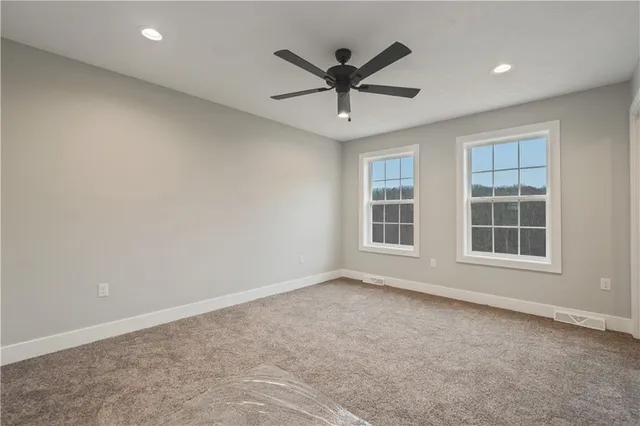 an empty room with window and ceiling fan