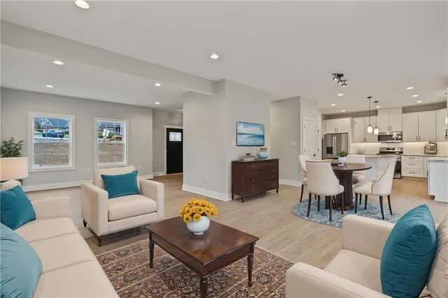 a living room with furniture kitchen and a table