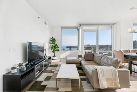 a living room with furniture a flat screen tv and a floor to ceiling window