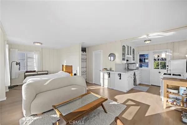 a room with a bed and a view of kitchen