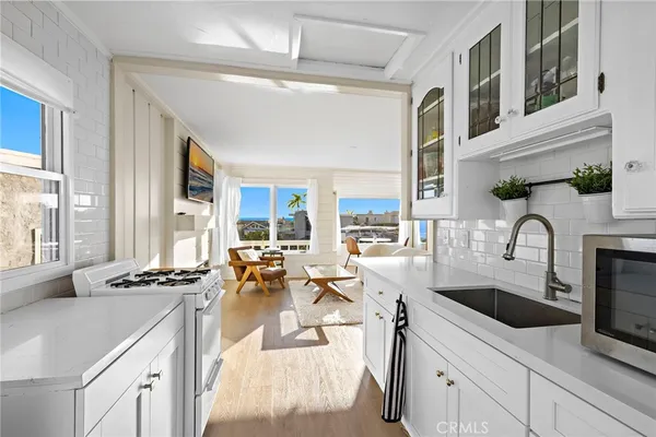 a kitchen with stainless steel appliances kitchen island granite countertop a sink and cabinets with wooden floor