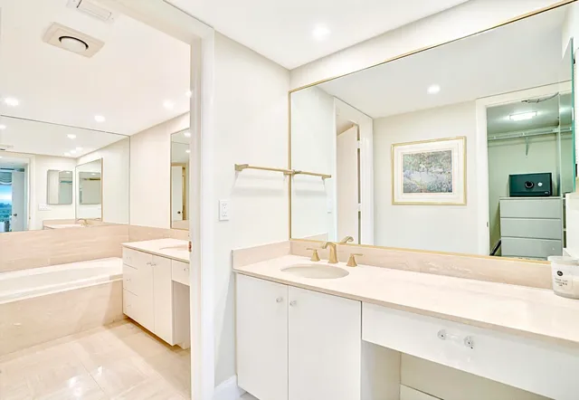 a bathroom with a tub sink and mirror