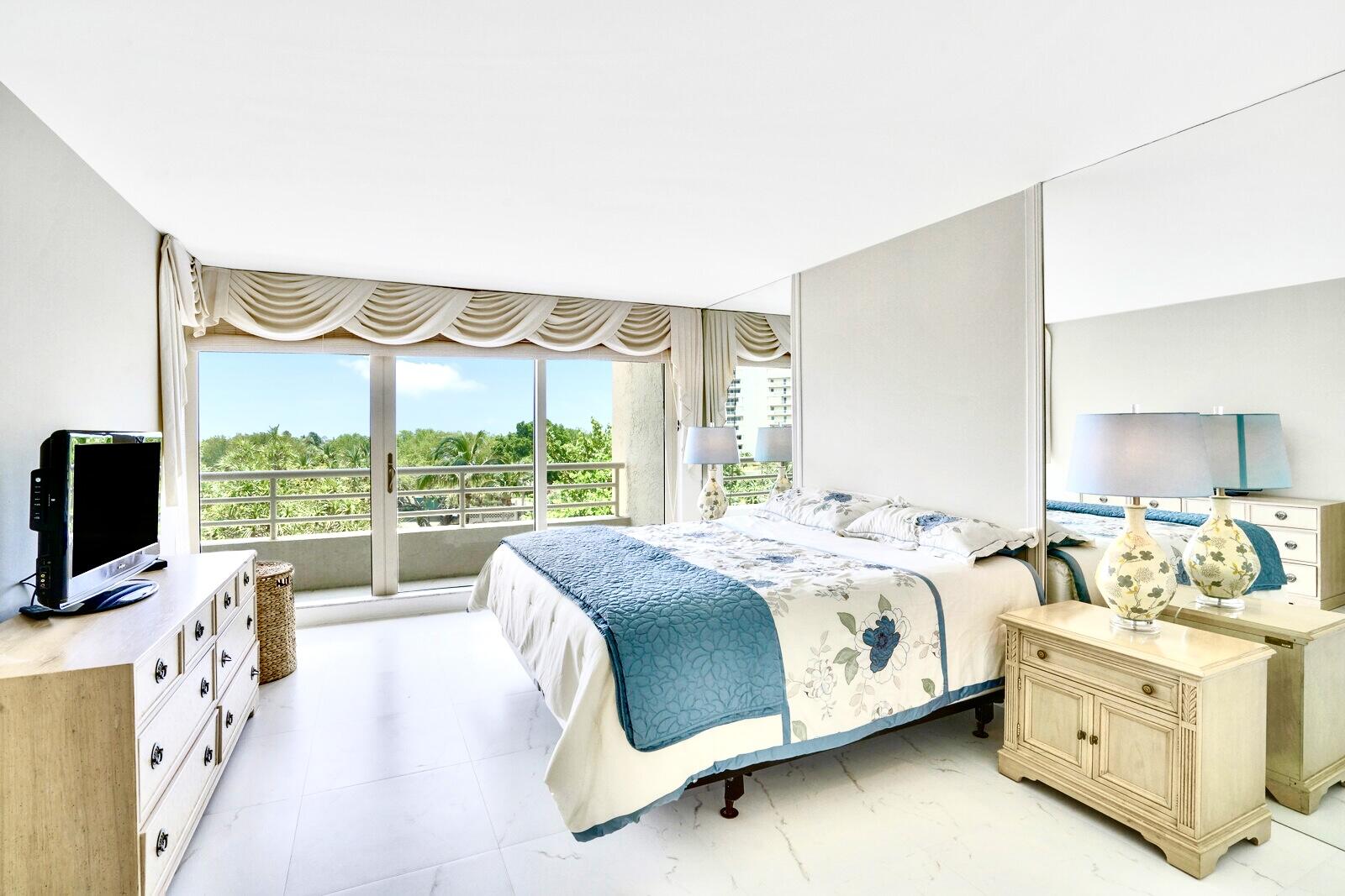 4101 North Ocean Boulevard, Unit D408 Boca Raton, FL 33431 - Photo 21 of 31 a spacious bedroom with a bed and a flat tv screen on the dresser