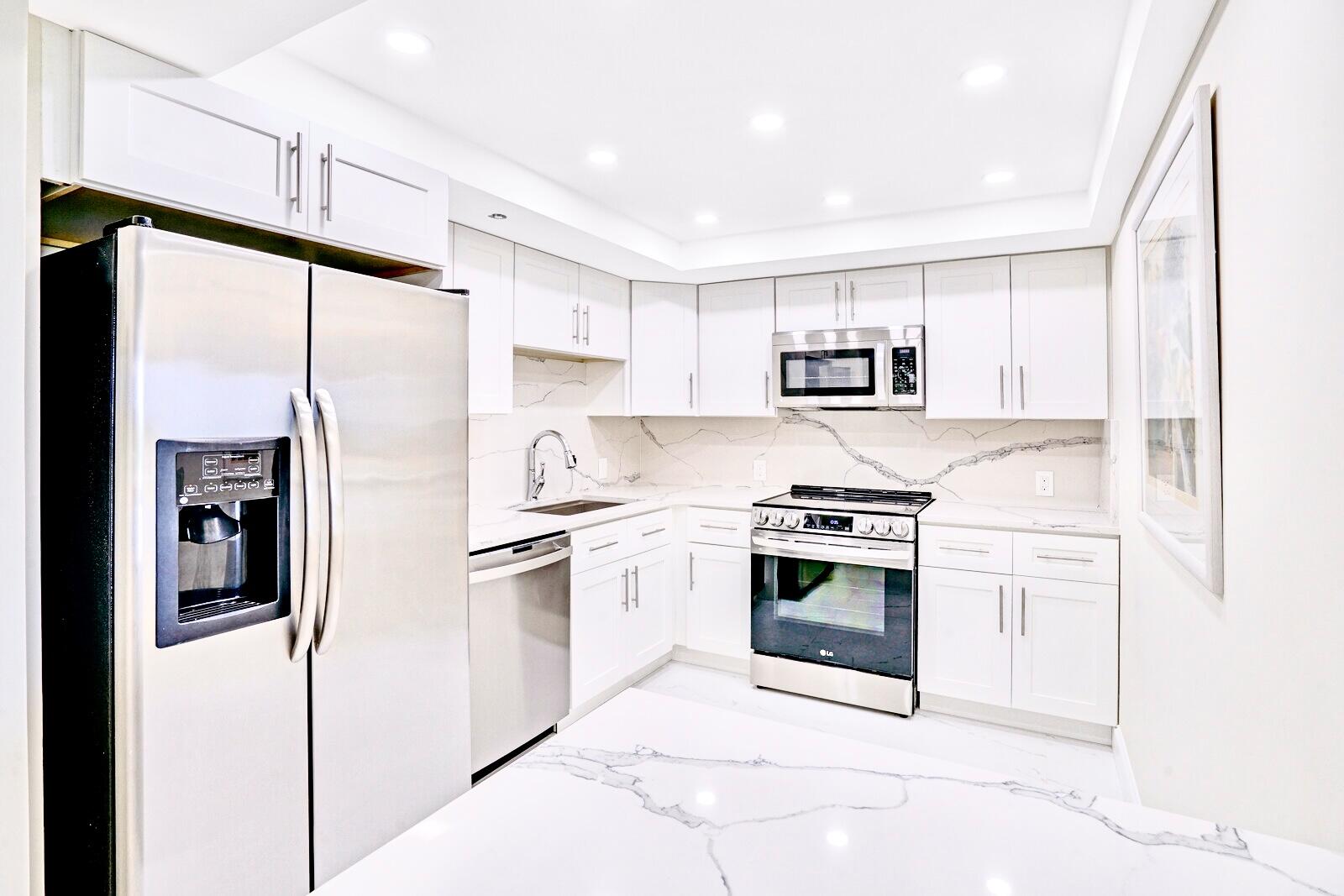 4101 North Ocean Boulevard, Unit D408 Boca Raton, FL 33431 - Photo 8 of 31 a kitchen with stainless steel appliances granite countertop a refrigerator stove oven and sink