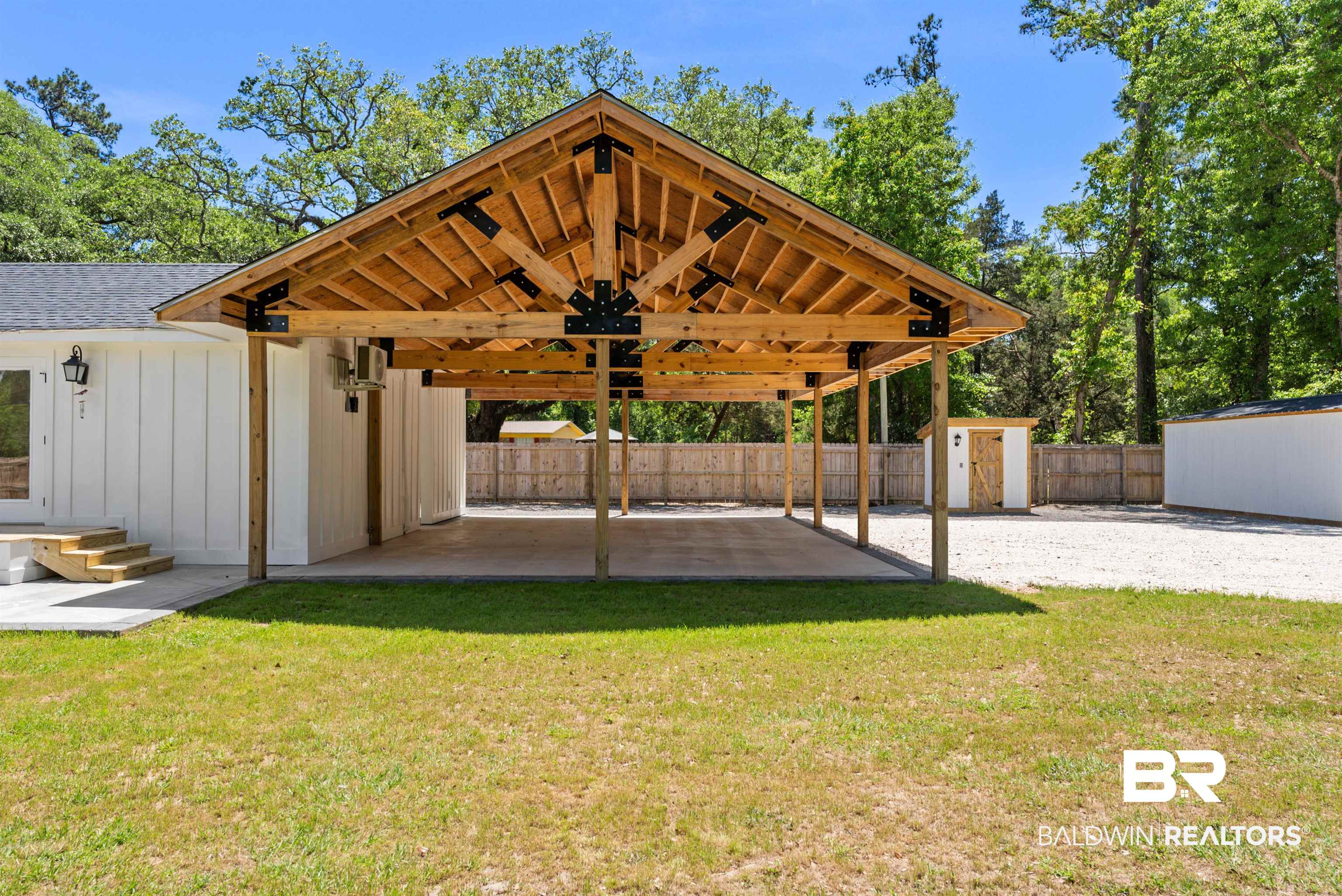 6447 Bemis Lane Bon Secour, AL 36511 - Photo 5 of 62 Open-air carport with exposed wood beams and black metal bracing