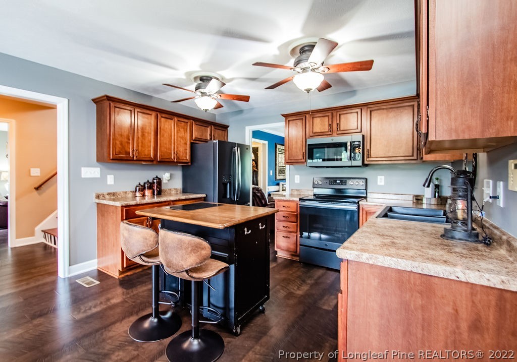 1105 John McMillan Road Hope Mills, NC 28348 - Photo 16 of 50 a kitchen with stainless steel appliances granite countertop a stove refrigerator and a sink
