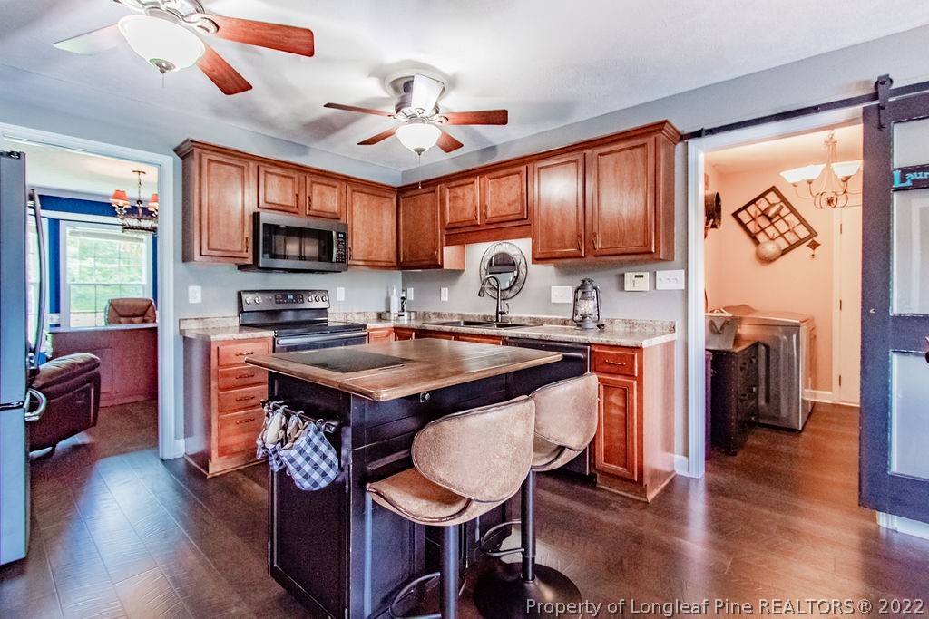1105 John McMillan Road Hope Mills, NC 28348 - Photo 18 of 50 a kitchen with stainless steel appliances granite countertop a sink a stove and a wooden floors