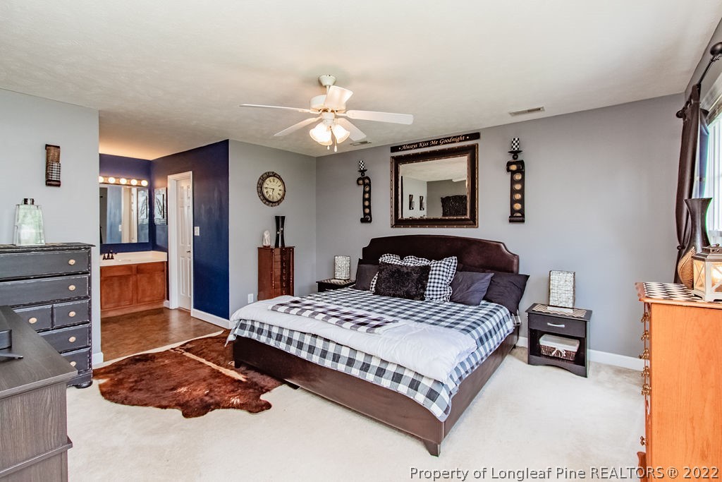 1105 John McMillan Road Hope Mills, NC 28348 - Photo 29 of 50 a bedroom with a bed and a chandelier