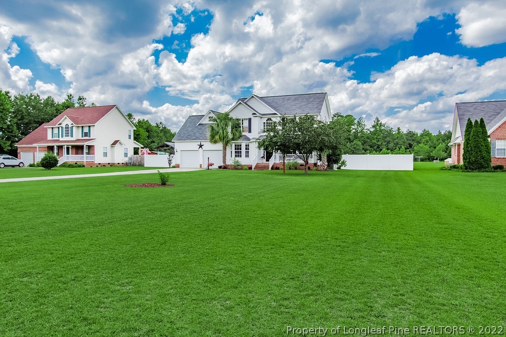 1105 John McMillan Road Hope Mills, NC 28348 - Photo 3 of 50 a view of a house with a big yard and large trees