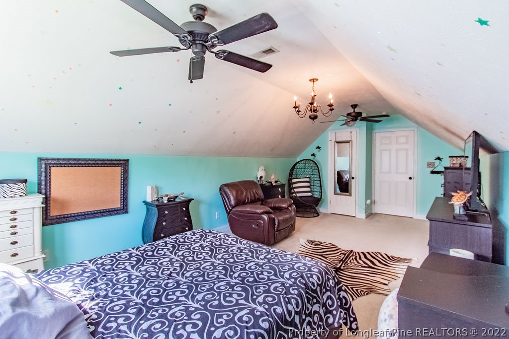 1105 John McMillan Road Hope Mills, NC 28348 - Photo 35 of 50 a bedroom with furniture and a chandelier