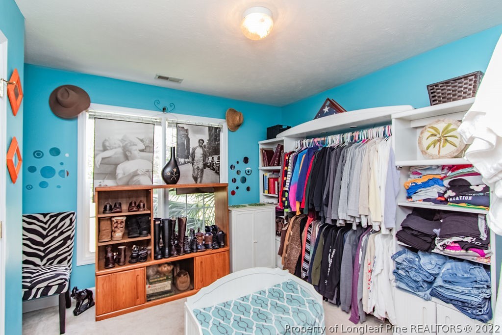 1105 John McMillan Road Hope Mills, NC 28348 - Photo 36 of 50 a view of walk in closet with clothes and shoes