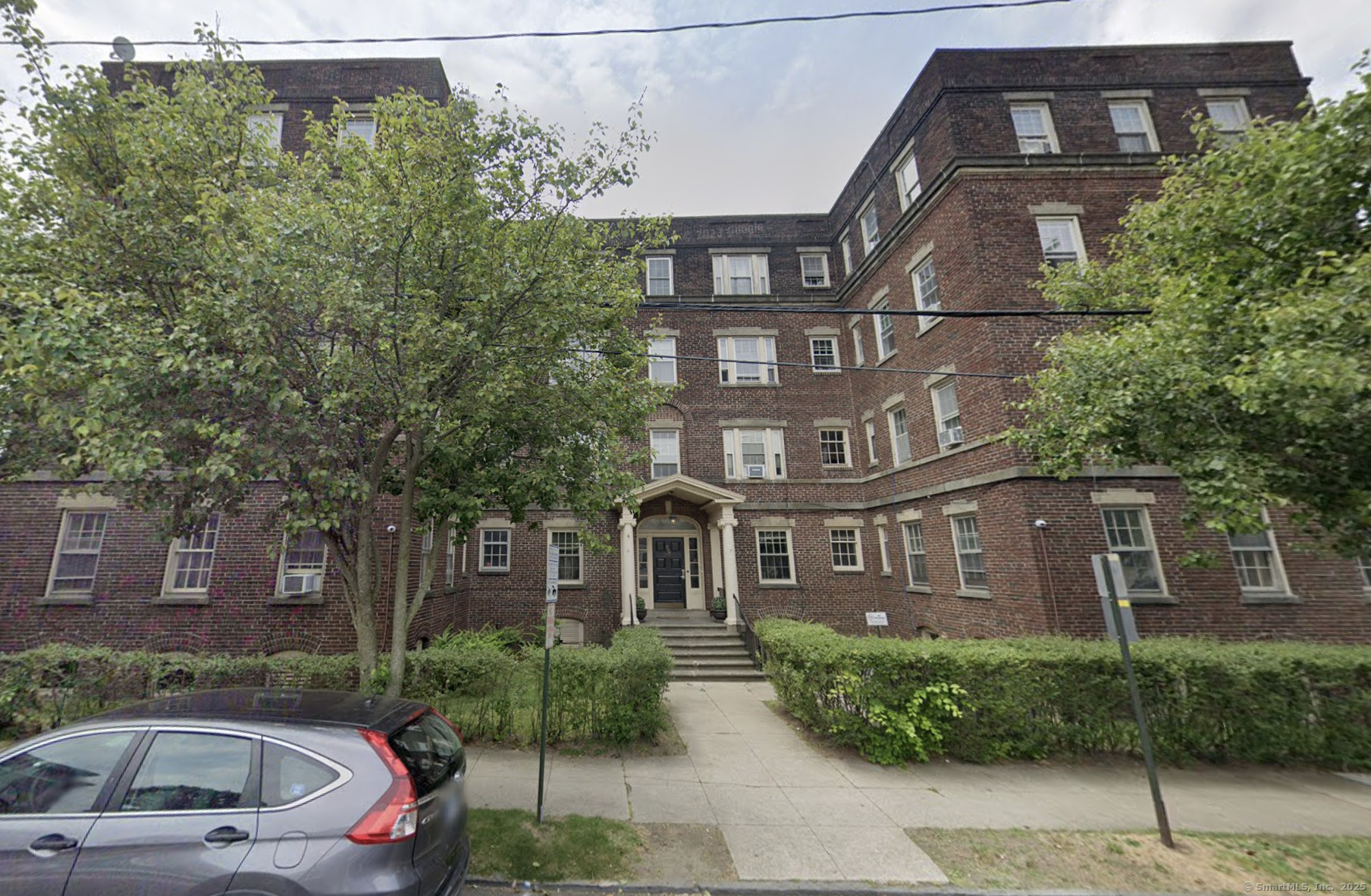 a front view of a residential apartment building with a yard