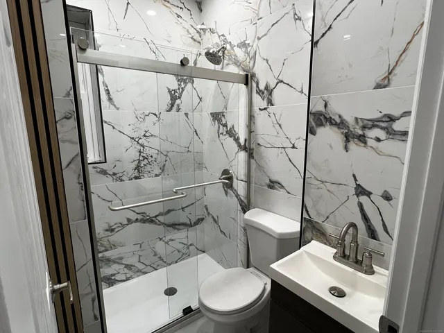 a bathroom with a toilet sink and shower