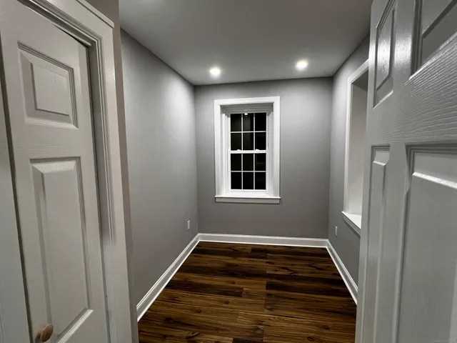 a view of a hallway with wooden floor and entryway