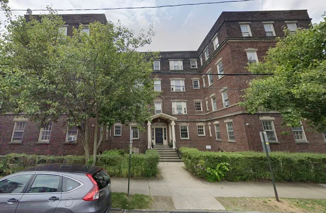 a front view of a residential apartment building with a yard