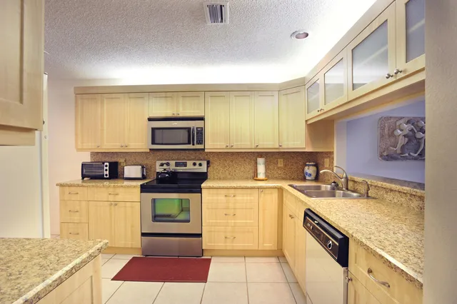 a kitchen with stainless steel appliances granite countertop a stove and a sink
