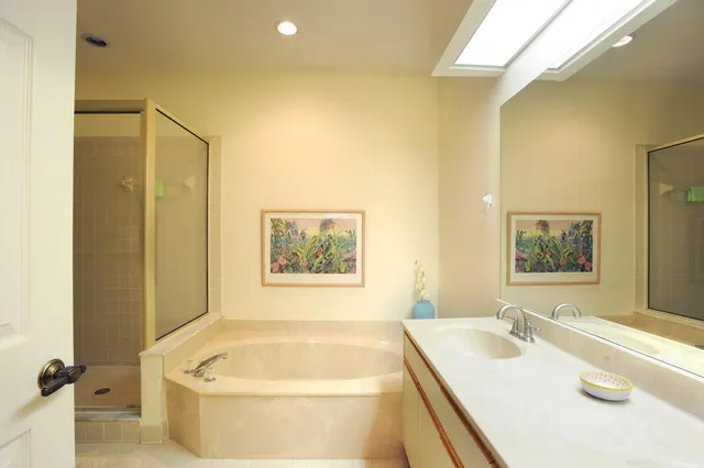 a bathroom with a tub a sink and wooden floor