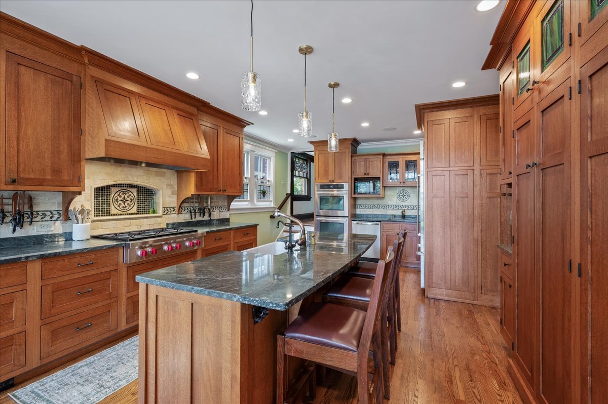 623 Forest Avenue Wilmette, IL 60091 - Photo 8 of 43 a kitchen with granite countertop a table chairs microwave and cabinets