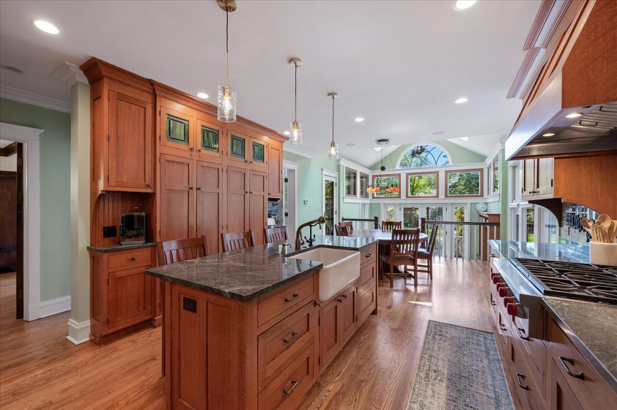 623 Forest Avenue Wilmette, IL 60091 - Photo 9 of 43 a kitchen with stainless steel appliances granite countertop a stove oven a dining table and chairs with wooden floor