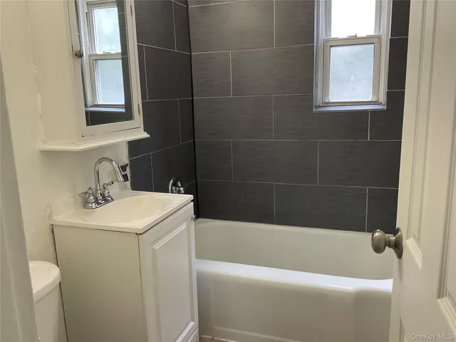 a bathroom with a sink a window and shower