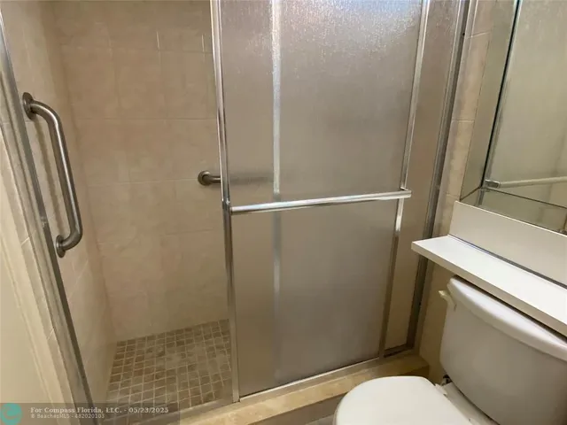 a bathroom with a toilet and a shower