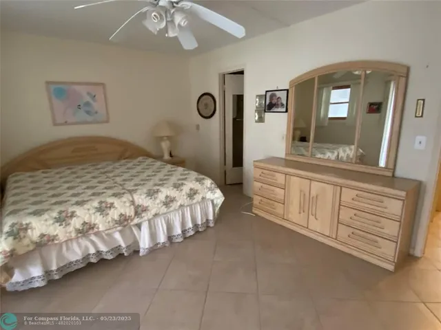 a bedroom with a bed mirror on wall and a large mirror