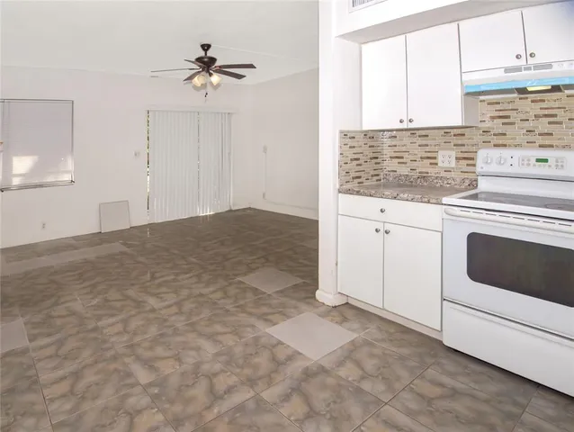 a kitchen with granite countertop a sink cabinets and window