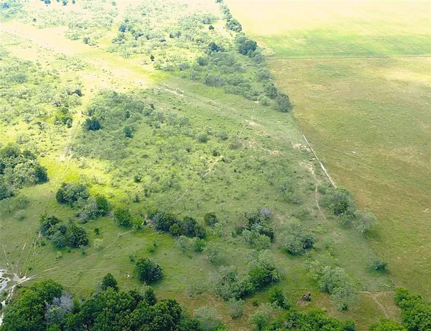 a view of a big yard with wooden fence