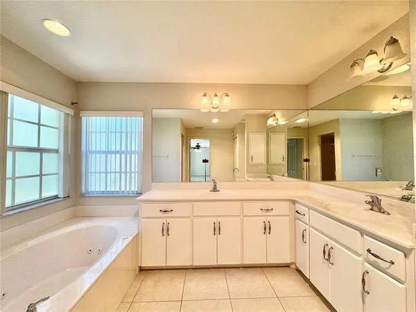 a spacious bathroom with a granite countertop sink mirror and bathtub