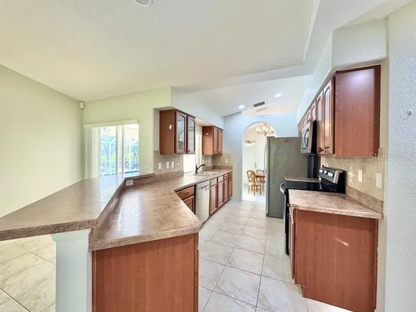 a kitchen with stainless steel appliances granite countertop a sink a stove top oven a counter space and cabinets