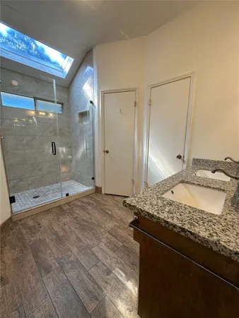 a bathroom with a granite countertop sink and a mirror