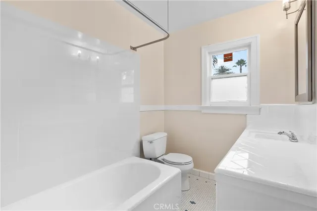 a white toilet sitting next to a bath tub