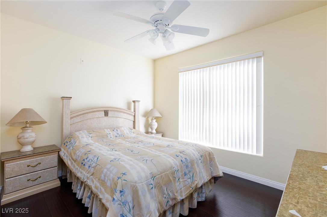 7185 South Durango Drive, Unit 201 Las Vegas, NV 89113 - Photo 13 of 27 Bedroom with dark wood-style flooring and ceiling fan with light