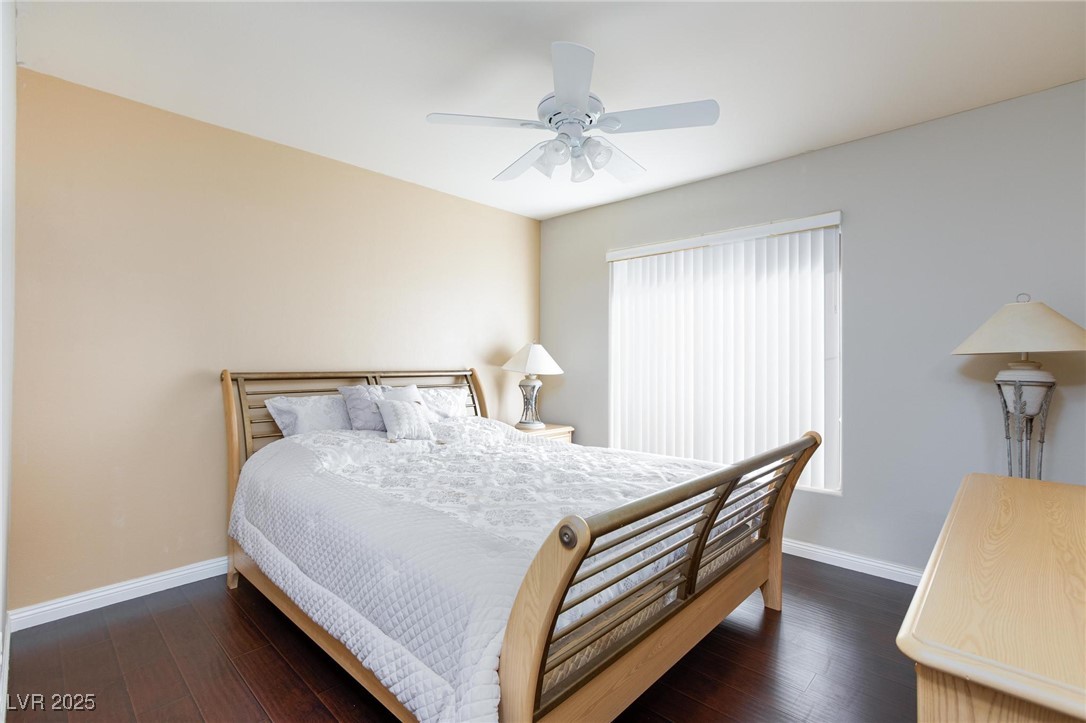 7185 South Durango Drive, Unit 201 Las Vegas, NV 89113 - Photo 17 of 27 Primary bedroom with dark wood finished floors and a ceiling fan with light