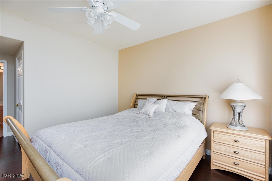 7185 South Durango Drive, Unit 201 Las Vegas, NV 89113 - Photo 18 of 27 Primary bedroom featuring a ceiling fan with light and dark wood-type flooring