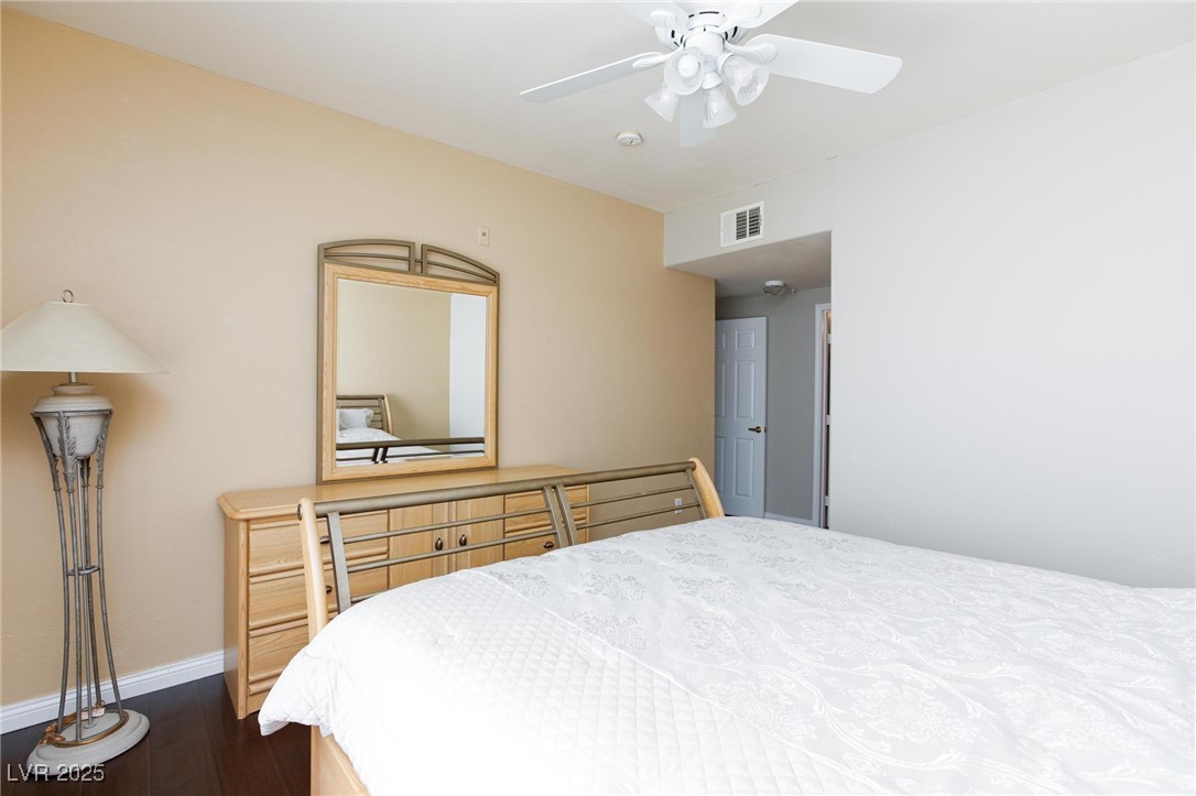 7185 South Durango Drive, Unit 201 Las Vegas, NV 89113 - Photo 19 of 27 Primary bedroom with dark wood finished floors and a ceiling fan with light