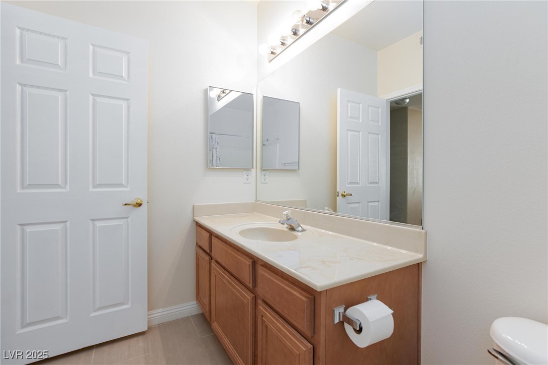 7185 South Durango Drive, Unit 201 Las Vegas, NV 89113 - Photo 22 of 27 Half bath featuring vanity and light tile patterned floors
