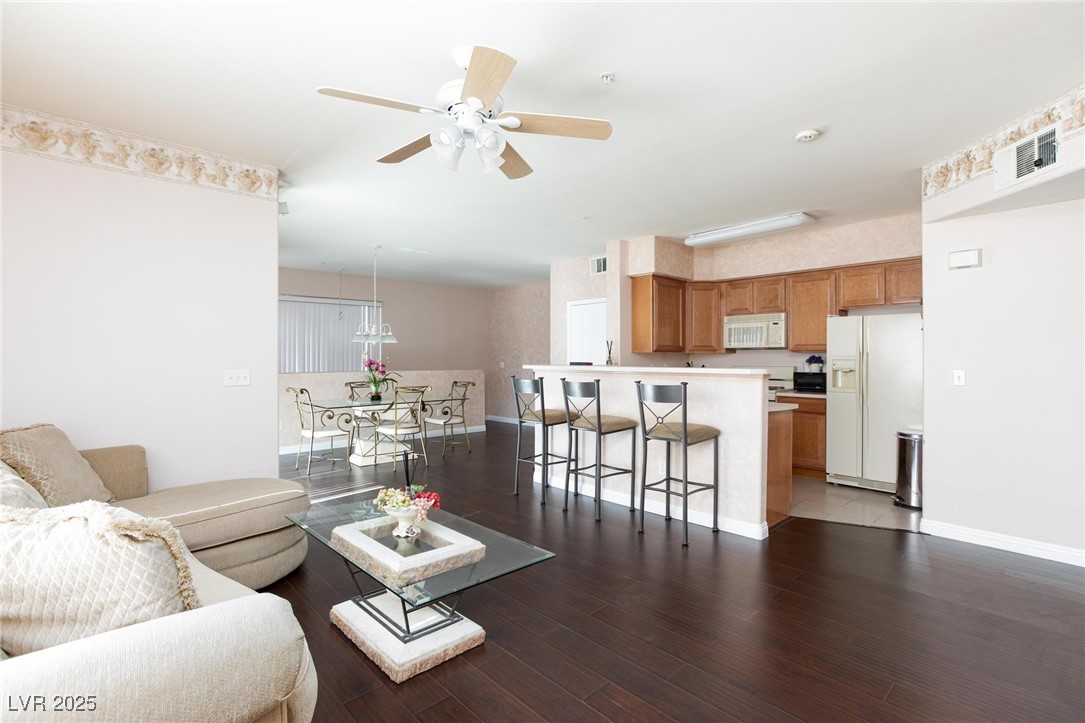 7185 South Durango Drive, Unit 201 Las Vegas, NV 89113 - Photo 6 of 27 Living area featuring dark wood-style flooring and ceiling fan and light